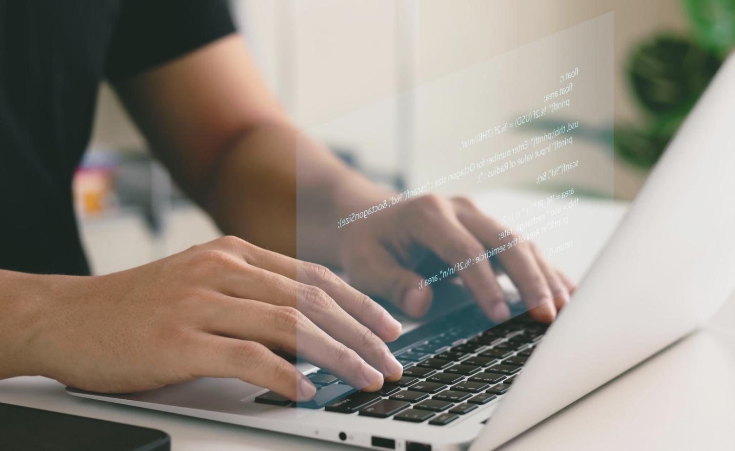 Intimate classroom setting with instructor providing one-on-one guidance to web design students